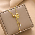 Gold-tone mini bow charm necklace with dangling crystal drops and chain