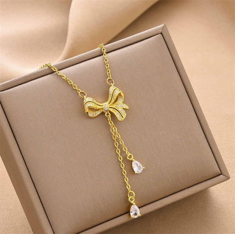 Gold-tone mini bow charm necklace with dangling crystal drops and chain