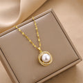 Gold charm pendant necklace with round white pearl bead and sparkling rhinestone halo