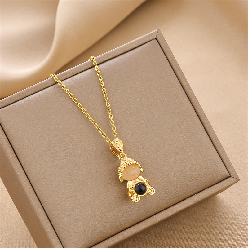 Gold chain doll pendant necklace with round charm and dangling decorative detail