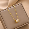 Gold cylindrical pendant necklace with sparkling cylinder charm and link chain in box.