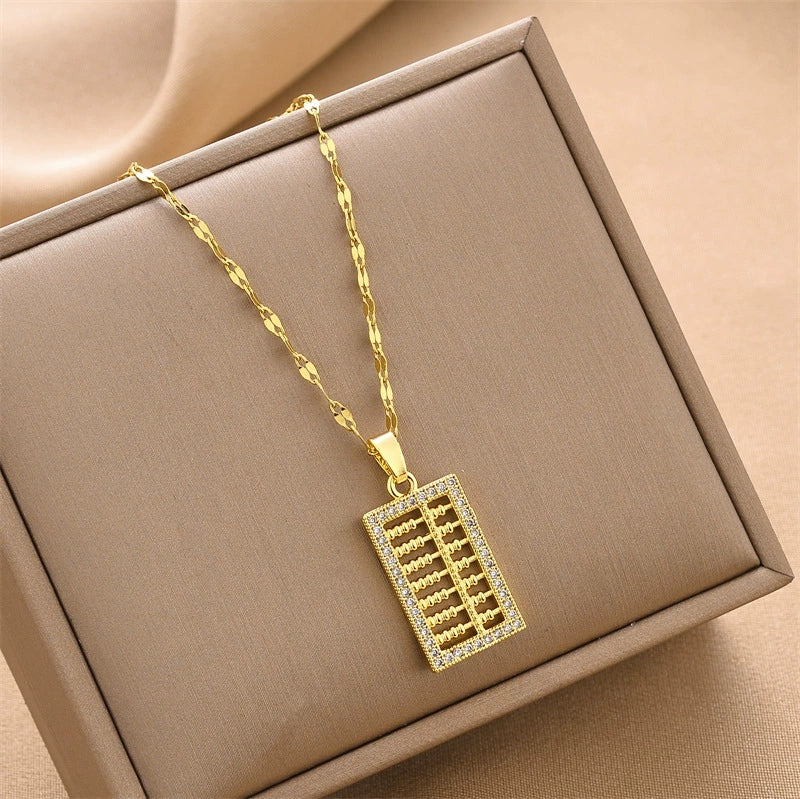 Gold-tone mini abacus charm necklace with rectangular crystal-studded pendant