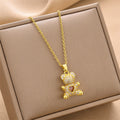 Gold-tone mini bear charm necklace with heart-shaped gem pendant on chain