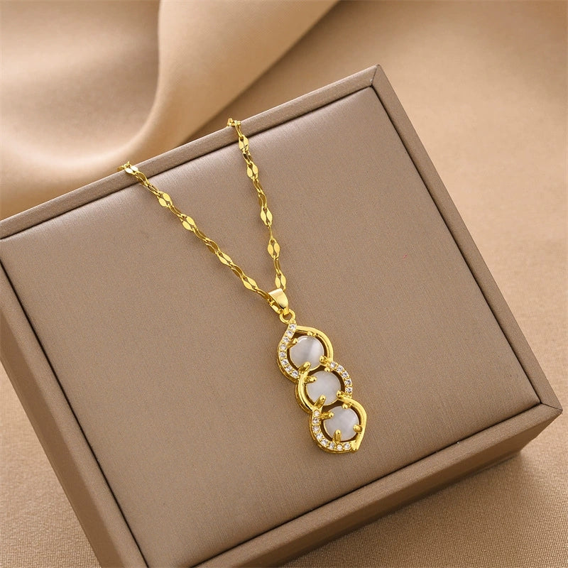 Gold-tone pendant necklace with three green bead charms, shown in gift box