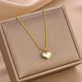 Gold-tone heart charm necklace with small heart pendant on a chain