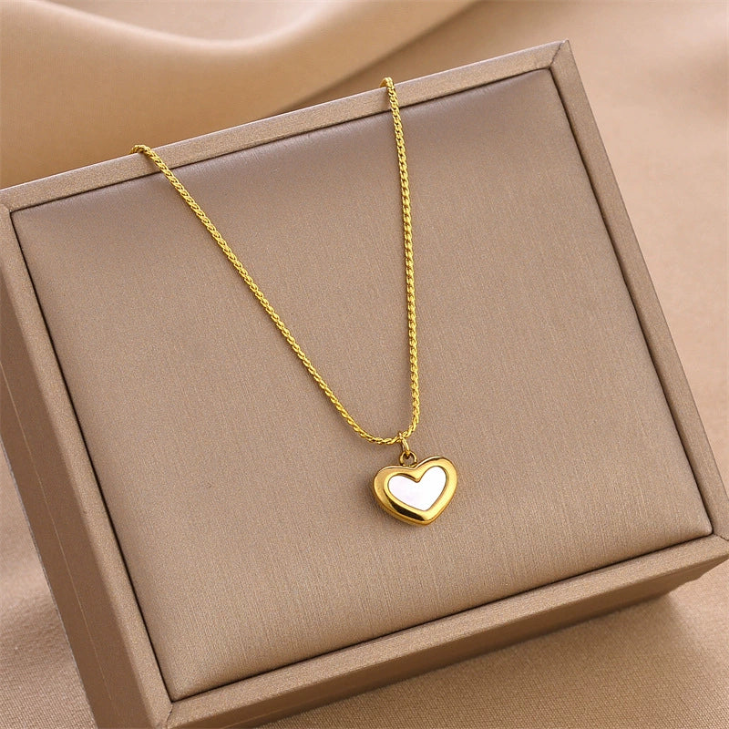 Gold-tone heart charm necklace with small heart pendant on a chain