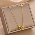 Gold-tone clover pendant necklace with slim chain, displayed in a box