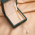 Gold leaf charm necklace with pearl drop pendant on a fine chain