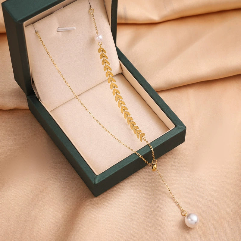 Gold leaf charm necklace with pearl drop pendant on a fine chain