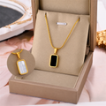 Gold square charm necklace with black enamel pendant on thin chain, gift box display
