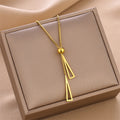 Gold double triangle charm necklace with ball pendant and two geometric triangles