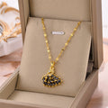Gold-tone wing pendant necklace with black center stones and clear accents