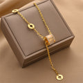 Gold-tone triple ring crystal charm necklace with circular logo charms