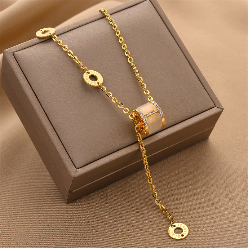Gold-tone triple ring crystal charm necklace with circular logo charms