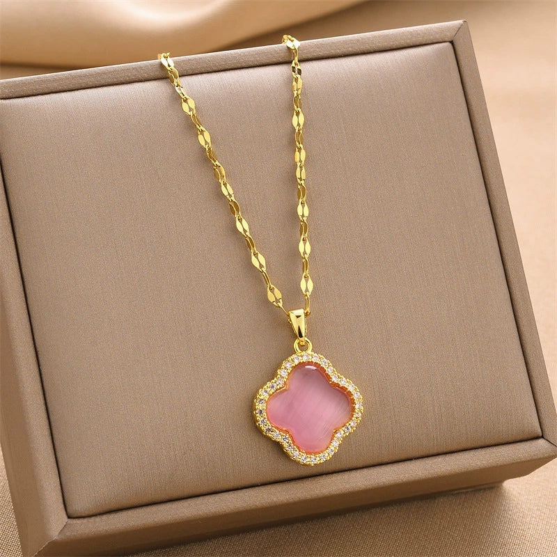 Gold-tone chain necklace with pink quatrefoil pendant framed by clear rhinestones