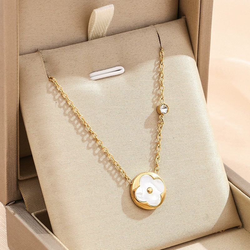 Gold-tone flower petal pendant necklace with round white inlay and dangling chain