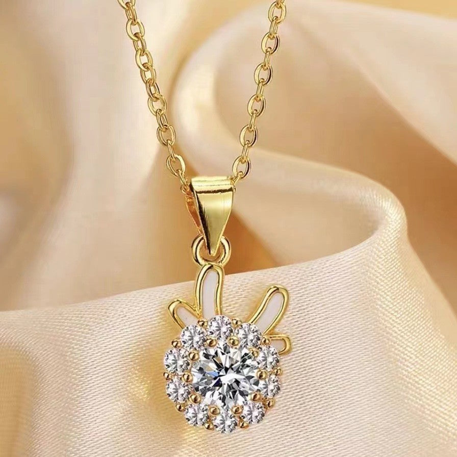 Gold-tone chain necklace with teardrop bail and round crystal flower pendant
