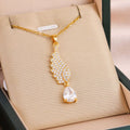 Gold chain necklace with crystal wing pendant and teardrop charm