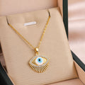 Gold eye charm necklace with oval blue eye pendant and rhinestone border