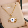 Gold-tone eye pendant necklace with blue enamel drop, on a chain in a gift box