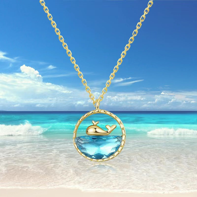 Gold mini shark ocean pendant necklace with oval blue crystal in circular frame