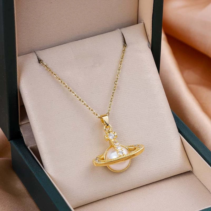 Gold-tone chain necklace with ringed planet pendant and small crystal accents