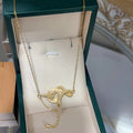 Gold-tone snake pendant necklace with white ring and drop charm on chain
