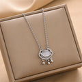 Silver lock charm necklace with oval pendant, rhinestone frame, and three bead accents