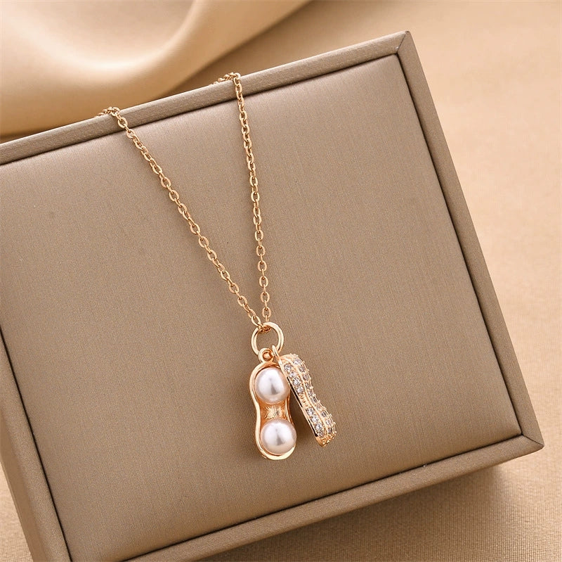 Gold-tone peanut charm necklace with two pearl drops, dangle detail