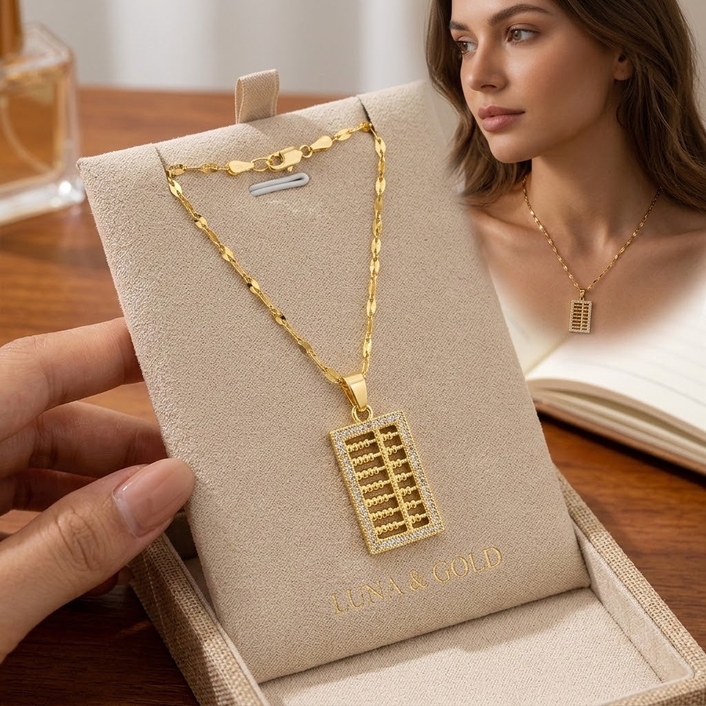 Gold-tone mini abacus charm necklace worn by a woman with square pendant