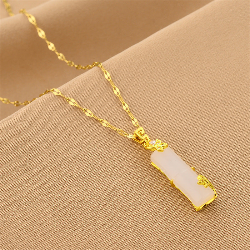 Gold chain necklace with white rectangular segment pendant, ornate gold ends
