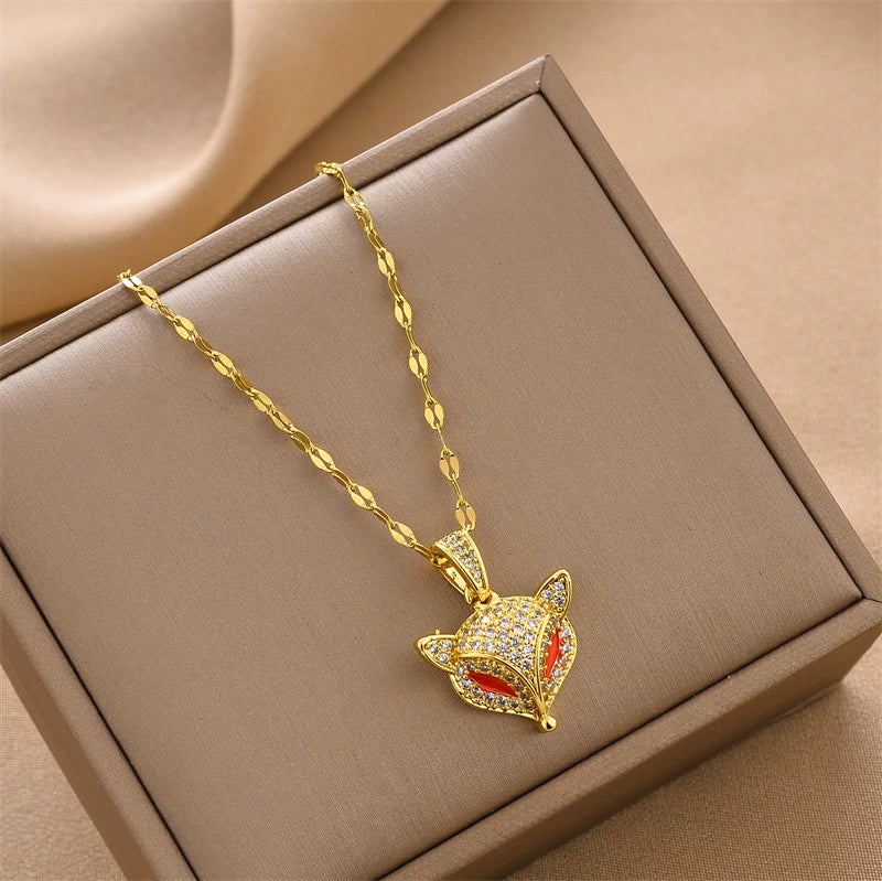 Gold-tone fox head charm necklace with red enamel and rhinestone details