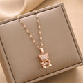 Gold-tone bear charm necklace with dangling crystal heart pendant