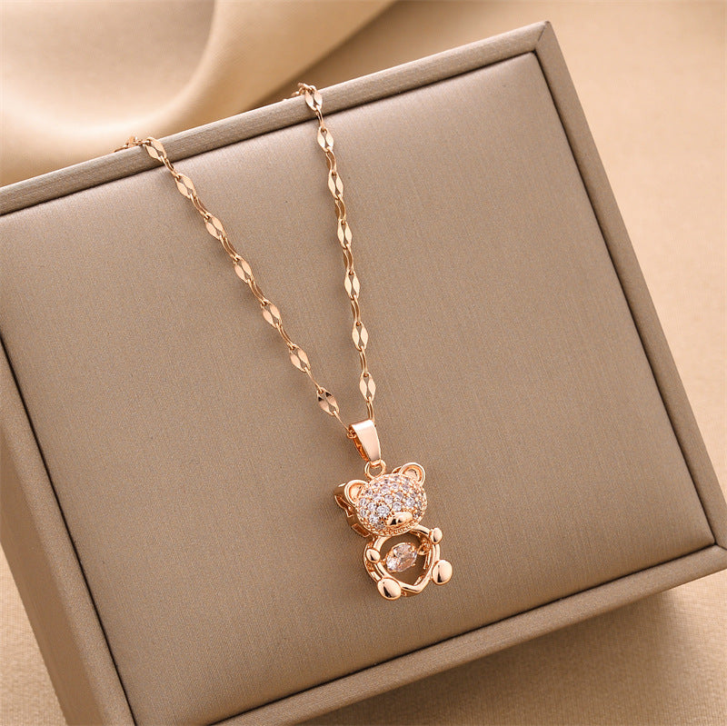 Gold-tone bear charm necklace with dangling crystal heart pendant
