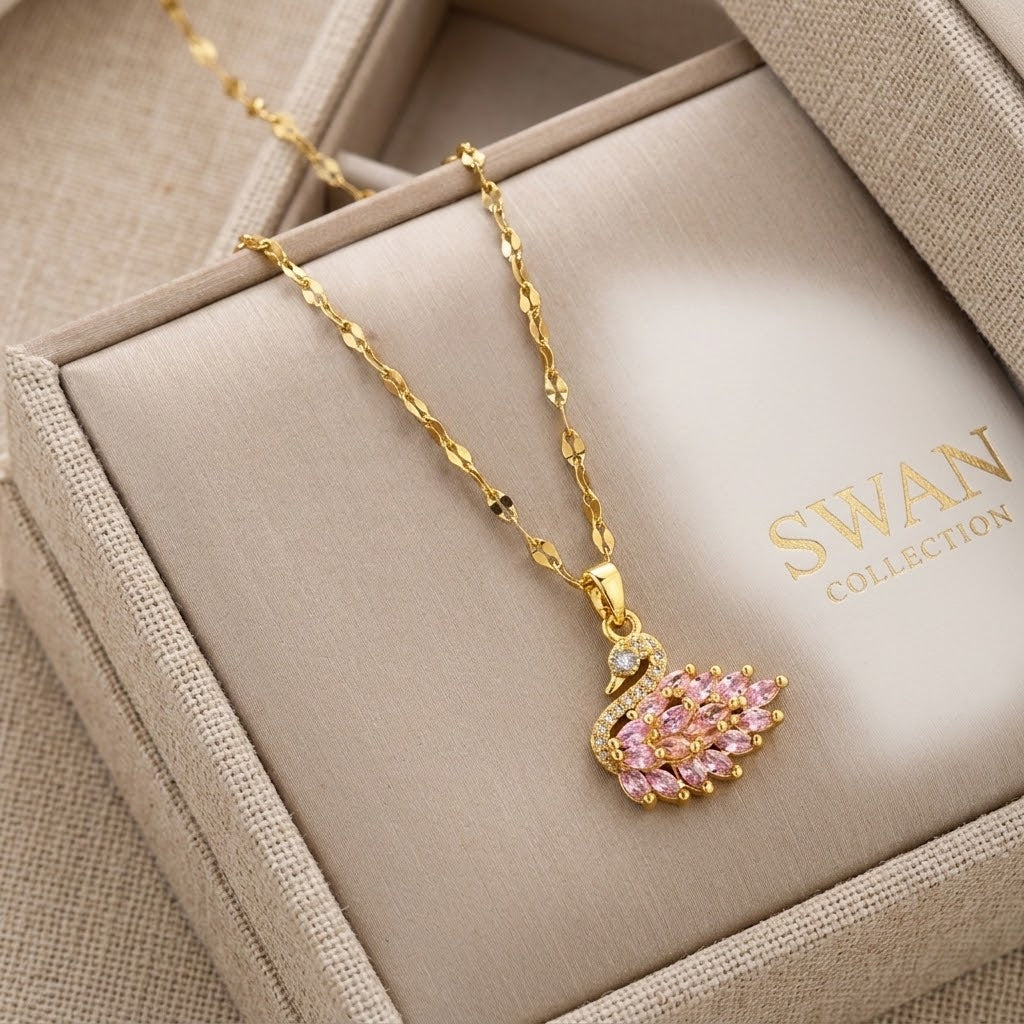 Gold-tone wing pendant necklace with pink gemstones and a clear stone halo