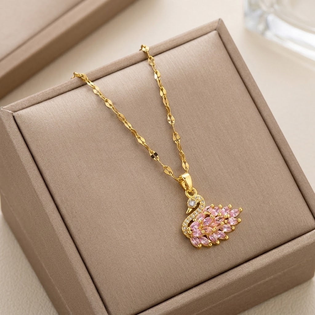 Gold-tone wing pendant necklace with pink gemstone wings and clear sparkle details