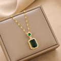 Gold charm necklace with a large square green gemstone pendant and emerald accents