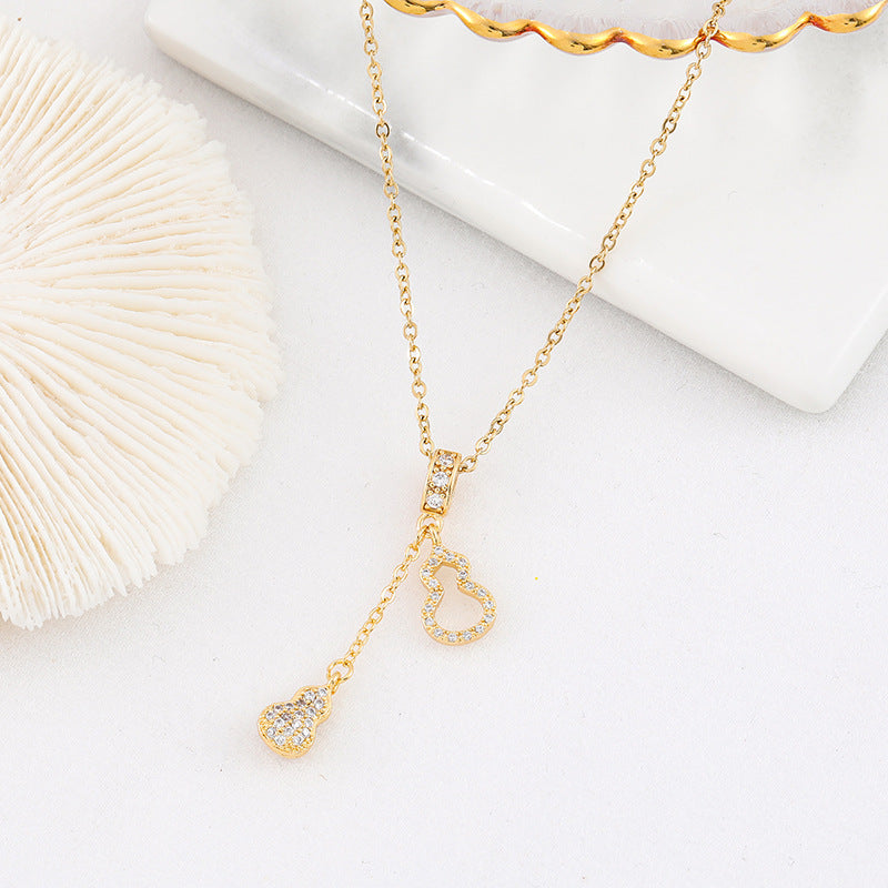 Gold-tone chain necklace with rhinestone gourd and drop charm