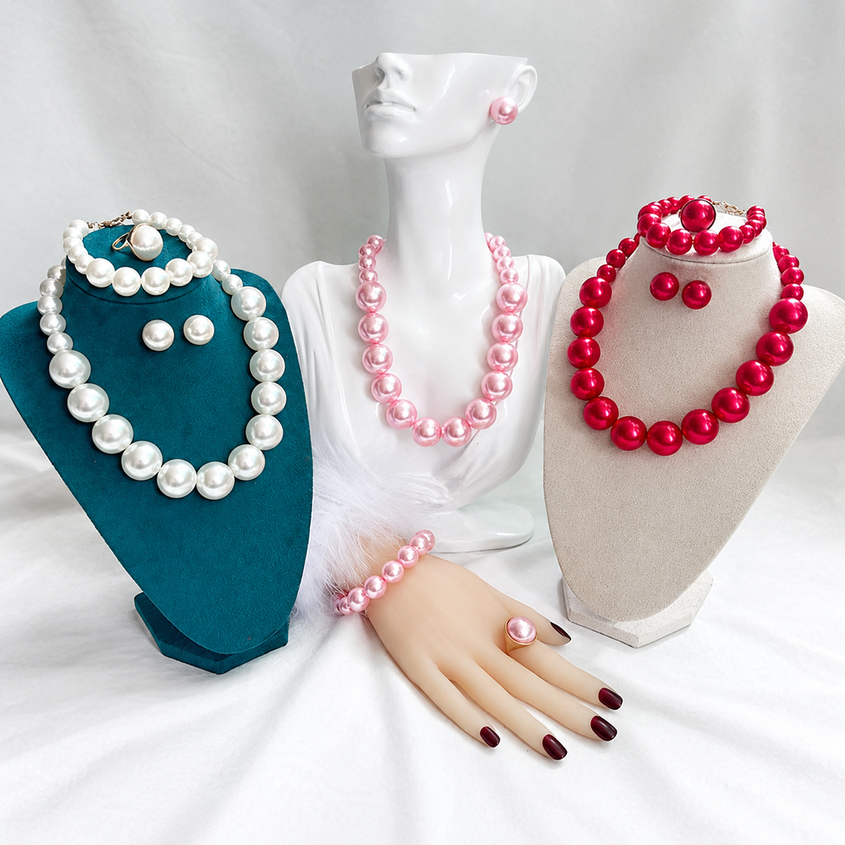 Faux pearl jewelry set display: white, pink, and red necklaces and earrings