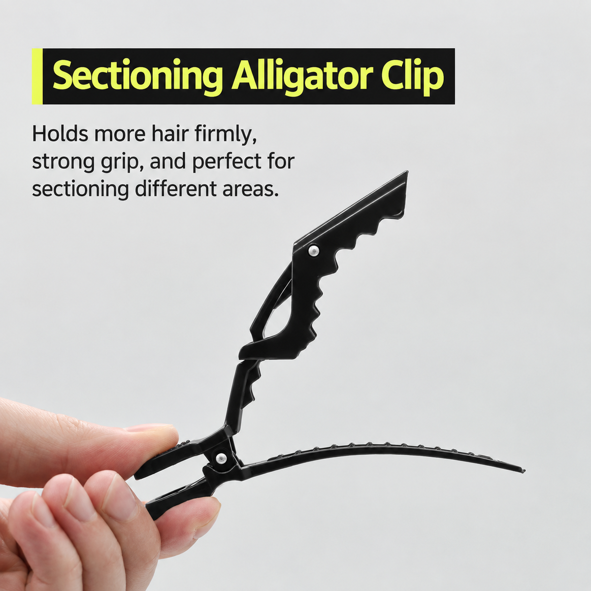 Black duckbill sectioning clip held in hand, open jaw with teeth