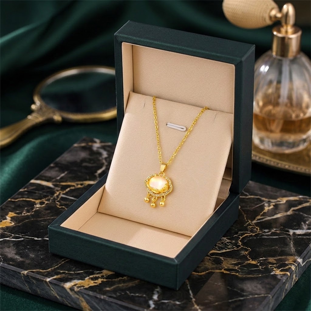 Gold-tone halo charm necklace with oval stone center and dangling bead accents