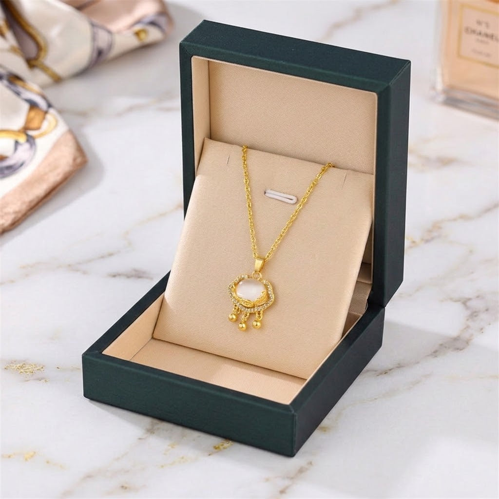 Gold-tone oval halo charm necklace with teardrop crystal frame and bead dangles