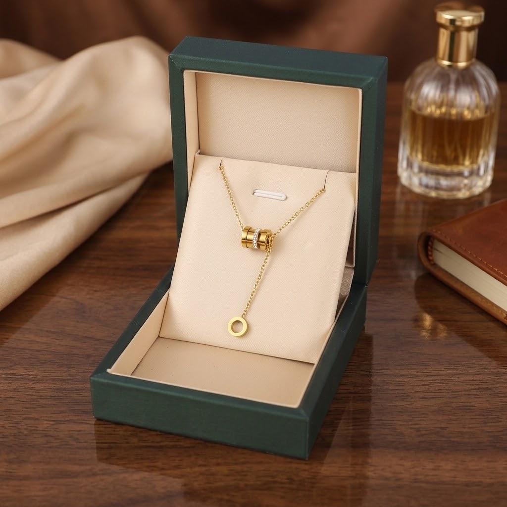 Gold-tone cylinder and ring pendant necklace in green gift box, ring centerpiece and charm