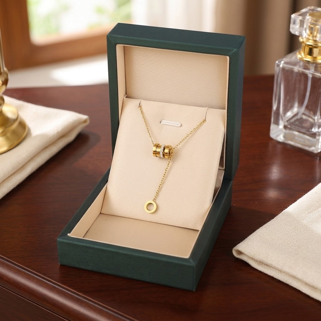 Gold-tone cylinder and ring pendant necklace in green gift box with ring drop charm