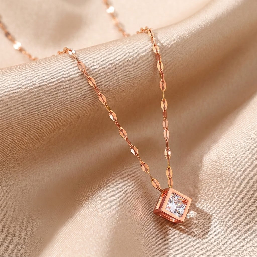 Rose gold square charm necklace featuring a pink-toned cubic centerpiece, close-up