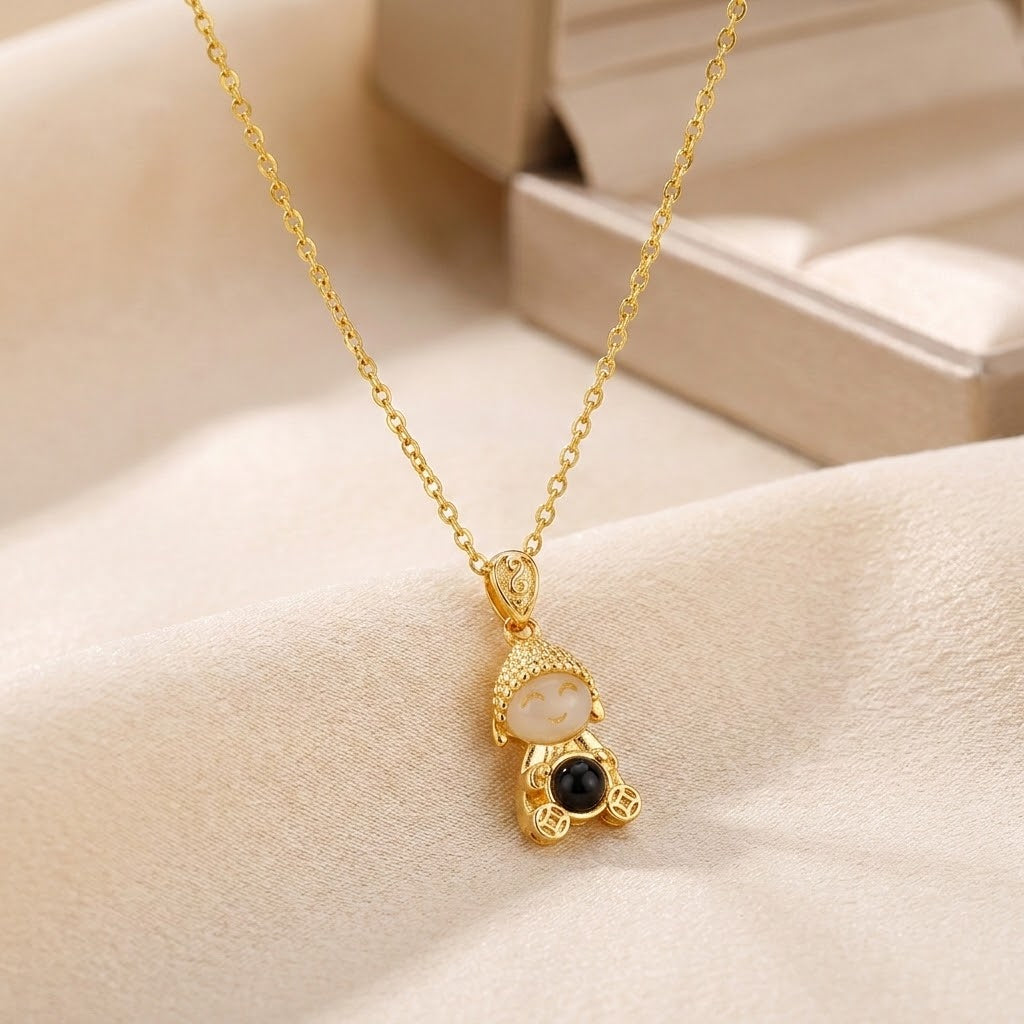 Gold doll pendant necklace with light face and black bead charms on chain