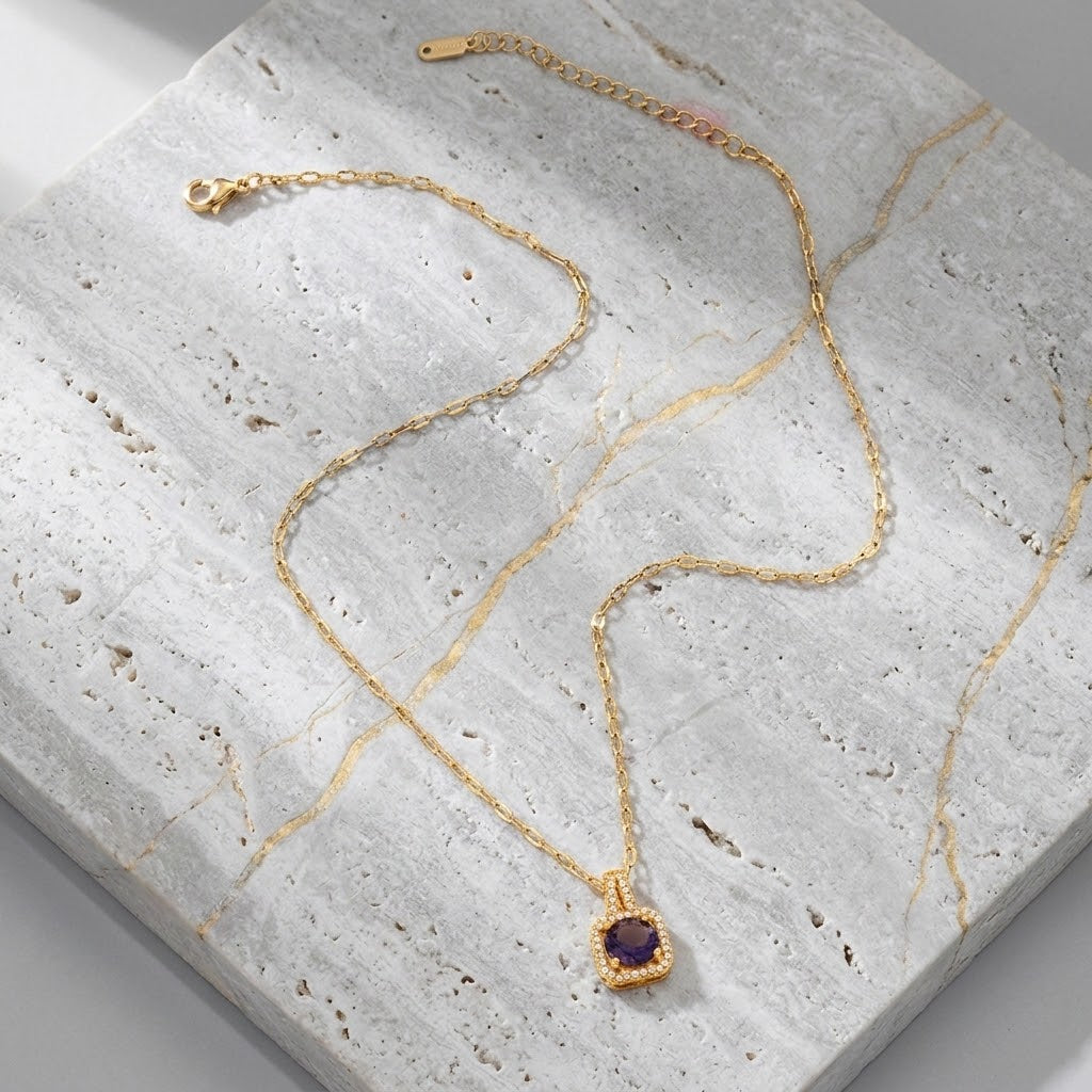 Gold pendant necklace with blue cushion gemstone in halo frame