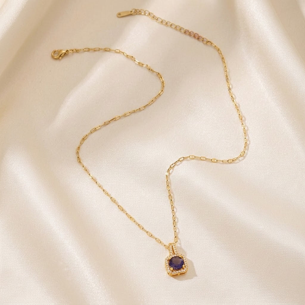 Gold pendant necklace with blue halo gemstone and fine link chain