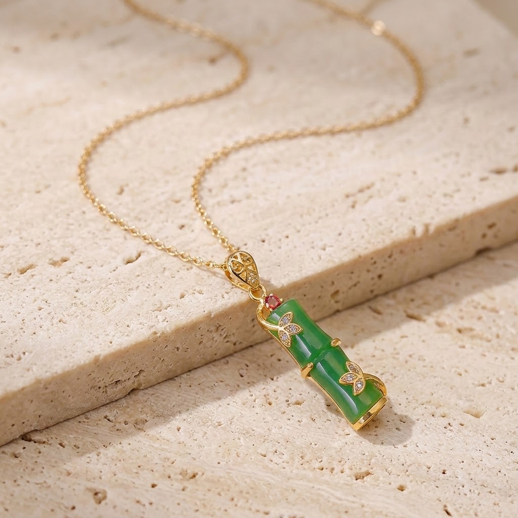 Gold necklace with green carved segment pendant and small heart crystal details