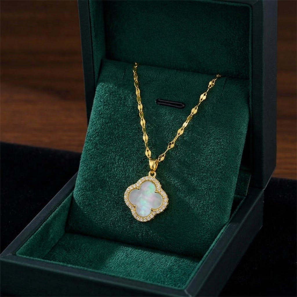 Gold clover pendant necklace with light blue/white center and sparkling halo